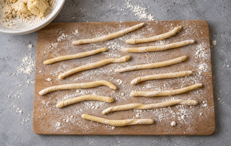 Acciuleddi (Sardinian Honey Twists), step 3: thin ropes of dough rolled out on the work surface