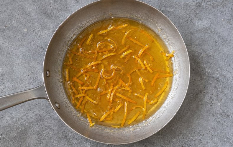 Acciuleddi (Sardinian Honey Twists), step 7: honey warming in a skillet with orange zest