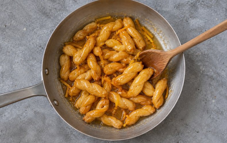 Acciuleddi (Sardinian Honey Twists), step 8: fried acciuleddi coated in the warm honey