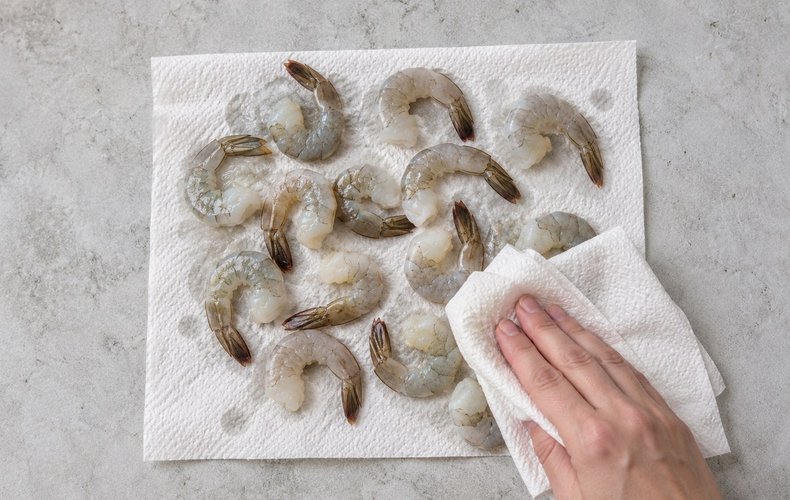 Air Fryer Shrimp Skewers, step 1: patting the shrimp tails dry with paper towels