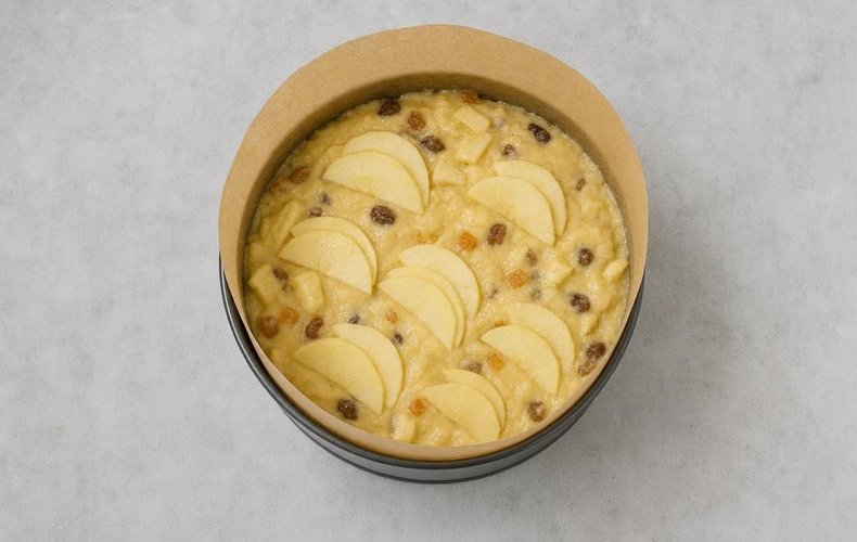 Cake topped with apple slices, ready for the oven