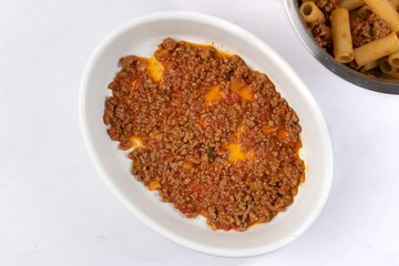 Ragù spread over the bottom of a baking dish