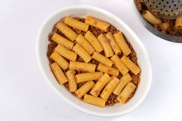 First layer of dressed pasta in the baking dish
