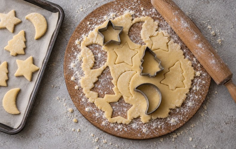 Befanini, step 3: cookies cut into Christmas shapes on a baking sheet