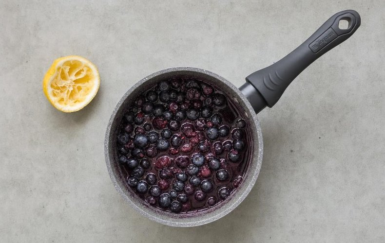 Blueberries cooking with lemon juice and sugar