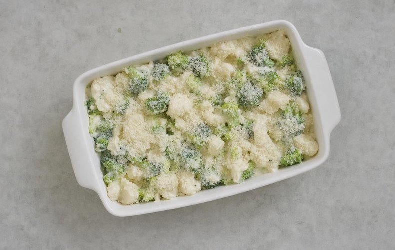 Broccoli and Cauliflower Gratin, step 4: vegetables in a buttered baking dish sprinkled with Parmigiano