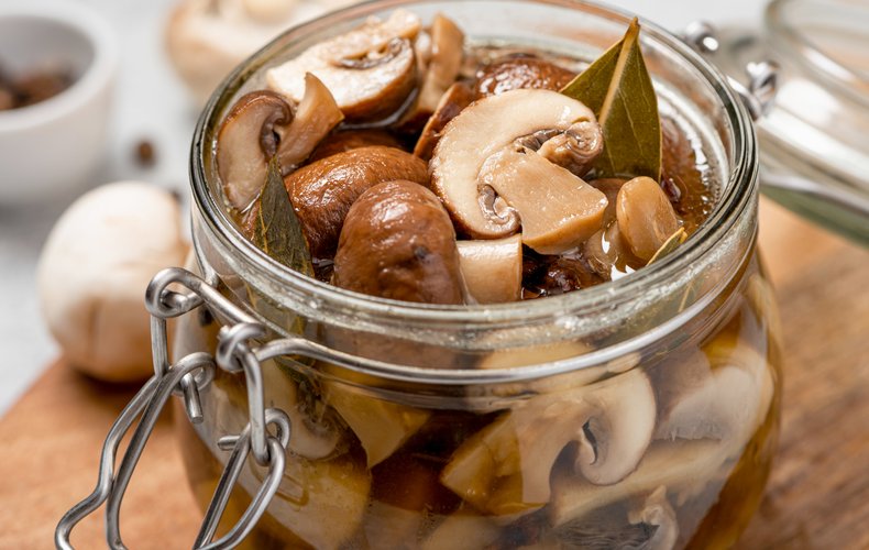 Jar of button mushrooms in olive oil