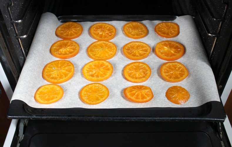 Candied orange slices on a lined baking sheet for the oven
