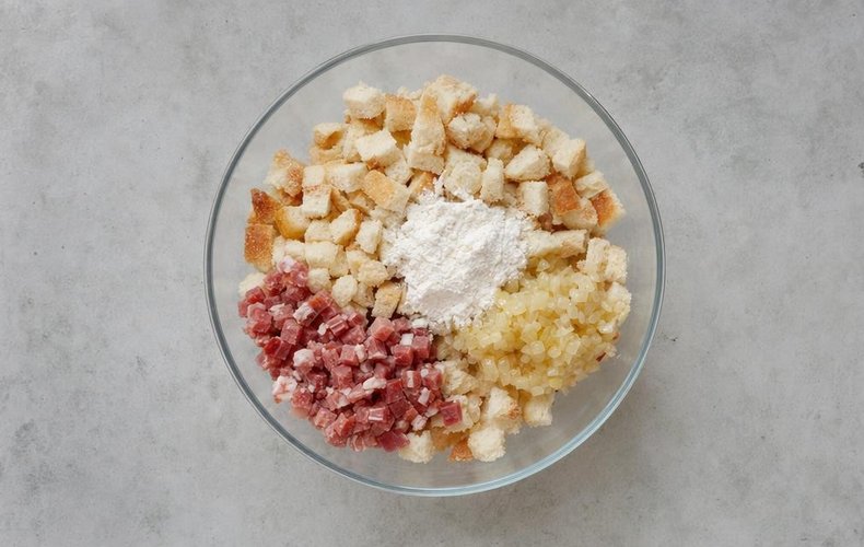 Canederli, step 1: cubed bread mixed with the cooked onion, flour and speck