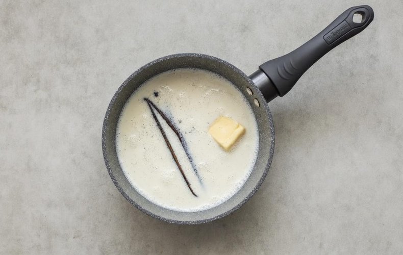 Canelés, step 1: vanilla bean heating in a saucepan with milk and butter