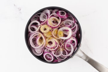 Red onions caramelizing in a skillet