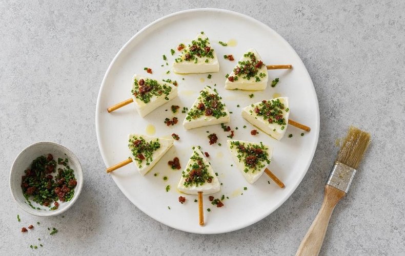 Cheese Christmas Trees, step 4: cheese triangles brushed with oil and coated in chives and sun-dried tomatoes