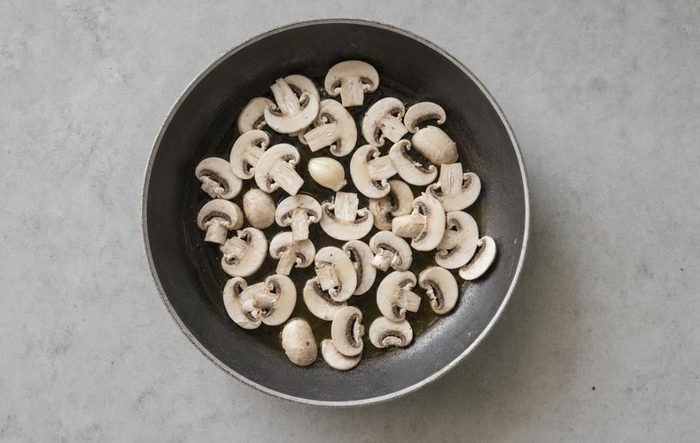 Cheese and Mushroom Bruschetta, step 2: sliced mushrooms in a skillet with oil and garlic
