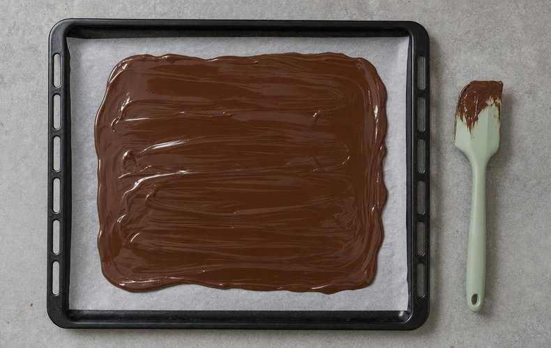 Chocolate Bark with Nuts and Berries, step 2: chocolate spread in a thin layer on a lined baking sheet