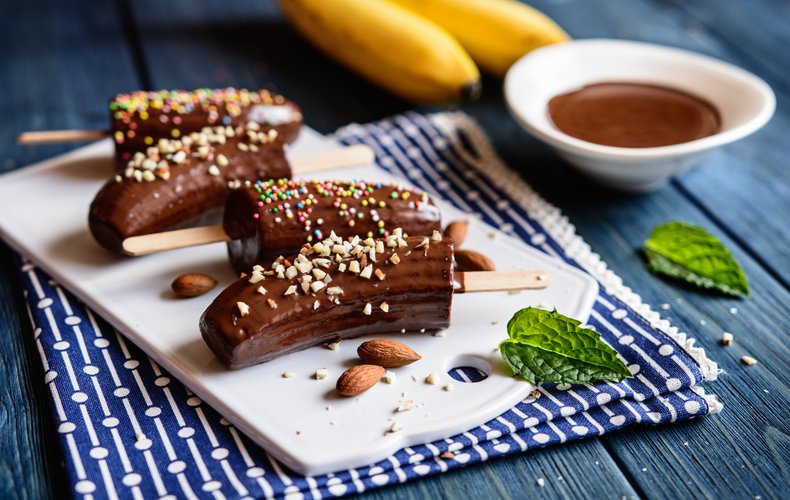 Chocolate-covered bananas with chopped almonds