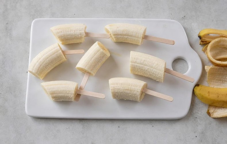 Chocolate-Covered Bananas, step 2: peeled banana halves on ice-pop sticks