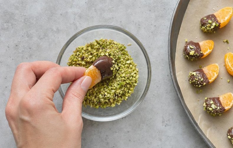 Chocolate-Dipped Mandarins, step 3: segments dipped in chocolate and chopped pistachios