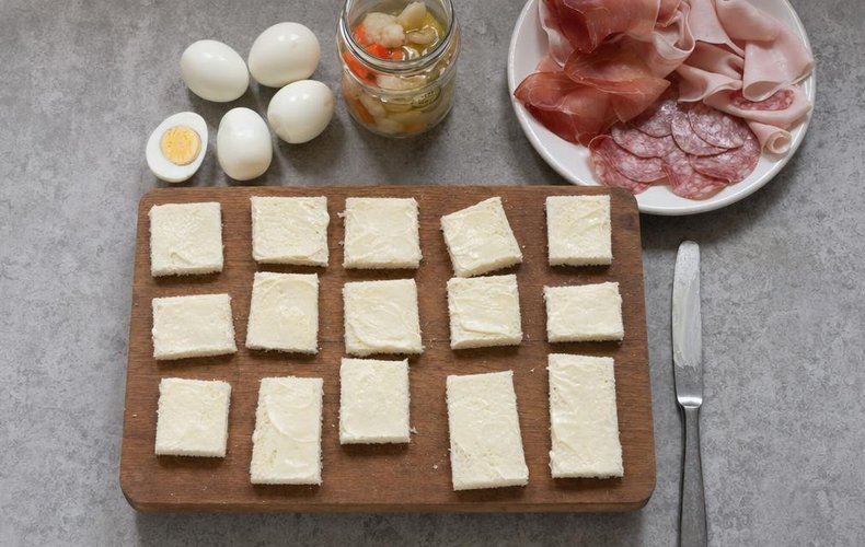 Christmas Canapés, step 2: spreading mayonnaise on the sandwich bread and adding the toppings