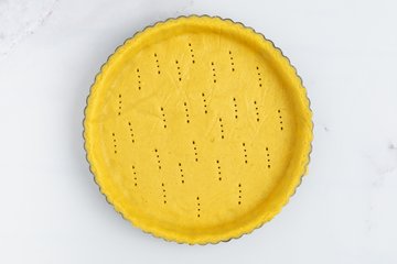 Pricking the tart base with a fork
