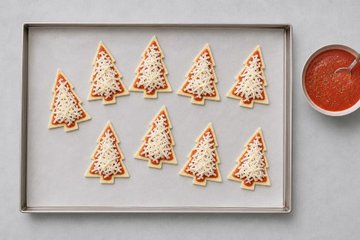 Christmas Tree Mini Pizzas, step 2: topping the trees with passata and mozzarella