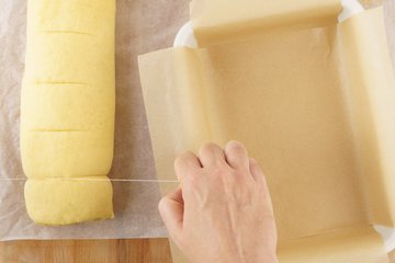 Cutting the cinnamon log into rolls with kitchen string
