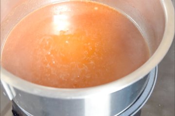 Apple juices boiling in a small saucepan
