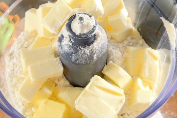 Flour, sugar, salt, and cold butter in a bowl for the pie crust