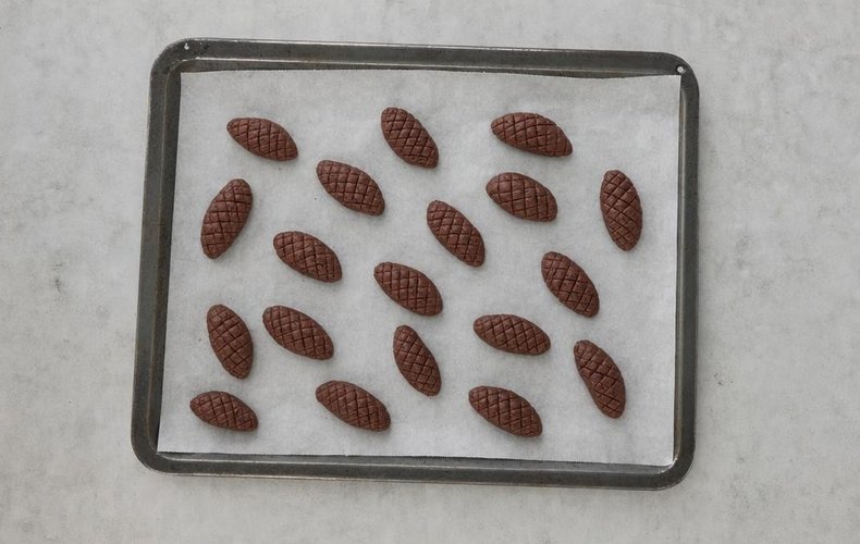Cocoa Pinecone Cookies, step 7: pinecones on a baking sheet lined with parchment paper