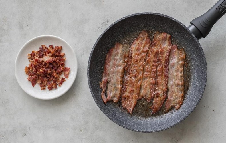 Creamy Lentil Soup with Crispy Bacon, step 4: bacon slices crisping in a skillet