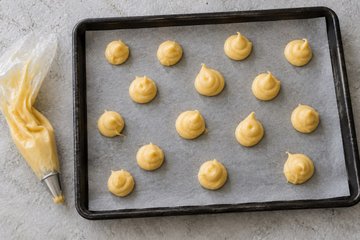 Croquembouche, step 3: piping the cream puffs onto the baking sheet