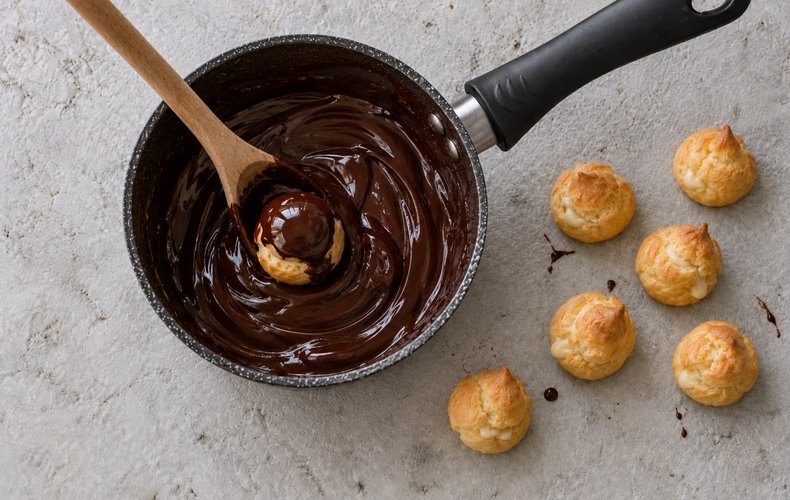 Croquembouche, step 6: dipping the cream puffs in chocolate