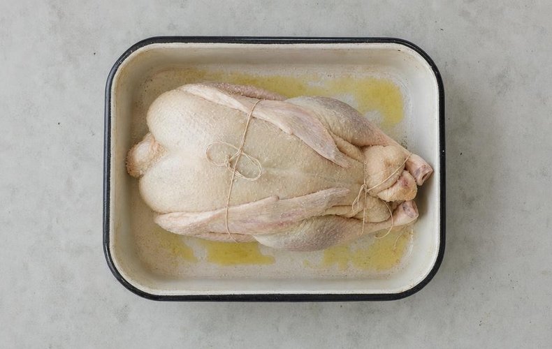 Duck à l'orange, step 1: the trussed duck in a casserole with oil and butter