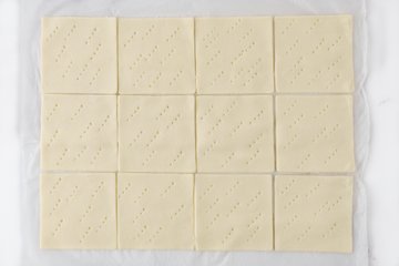 Pricking the pastry squares with a fork