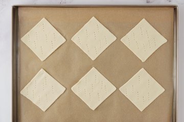 Pastry diamonds on a baking sheet lined with parchment paper