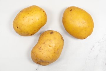 Slicing the potatoes thinly with a mandoline