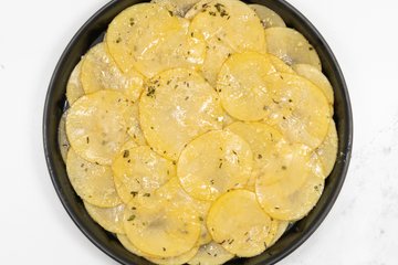 Adding cubes of Taleggio over the potatoes