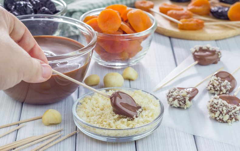 Chocolate fruit lollipops topped with chopped hazelnuts