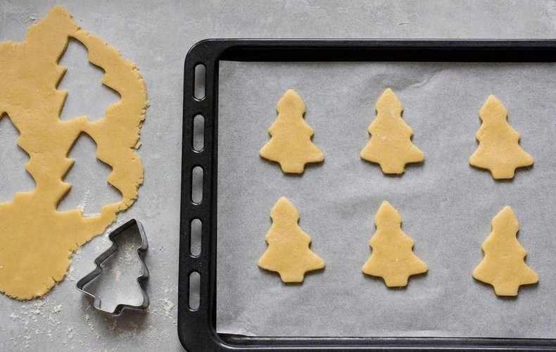 Glazed Christmas Tree Cookies, step 2: tree-shaped cookies on a lined baking sheet
