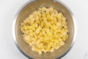 Mixing the seasoned crumb-coated potatoes