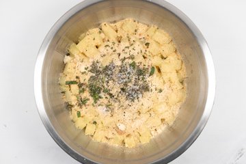 Adding grated cheese, herbs and garlic to the potatoes