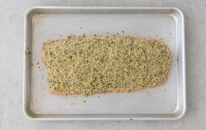 Herb and breadcrumb crust pressed onto the salmon fillet