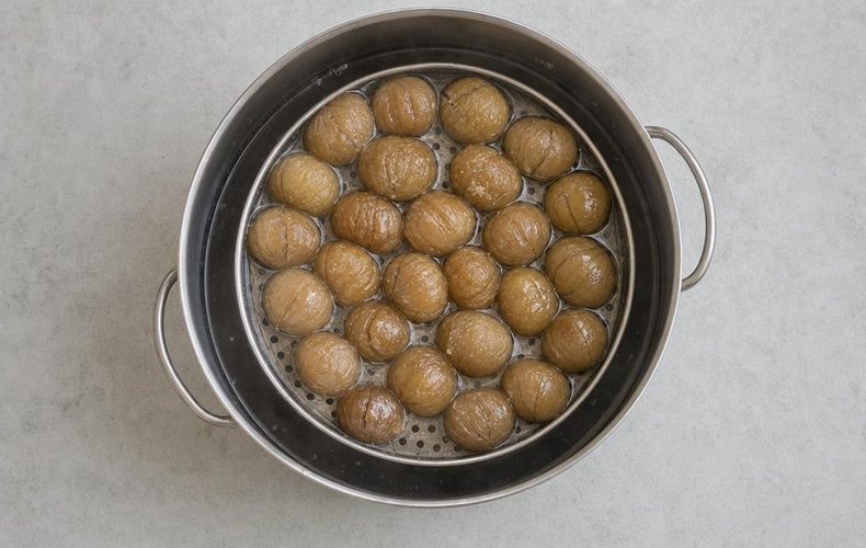 Homemade Marrons Glacés, step 5: chestnuts in the basket cooking in sugar syrup