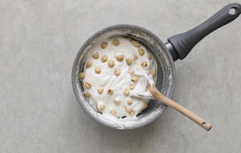 Homemade Soft Torrone, step 5: toasted hazelnuts stirred into the thickened mixture