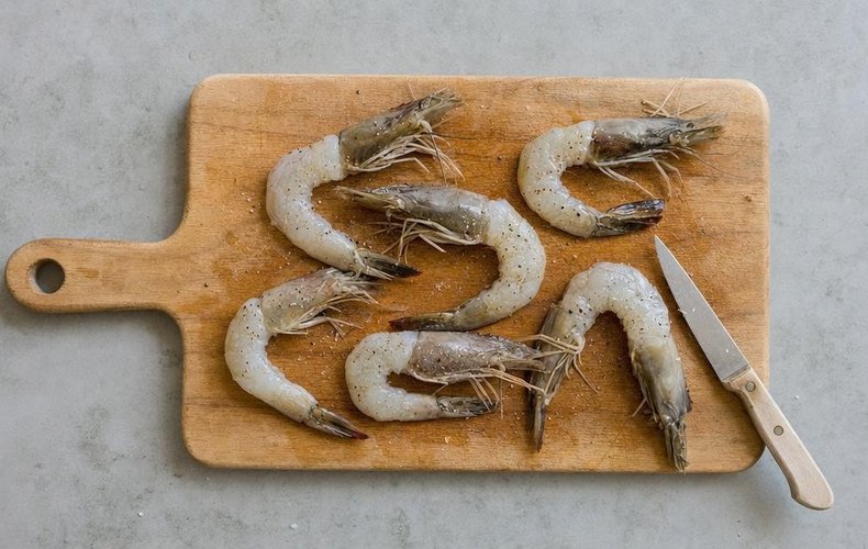 Kataifi-Wrapped Jumbo Shrimp, step 1: shelled shrimp with head and tail, seasoned with salt and pepper