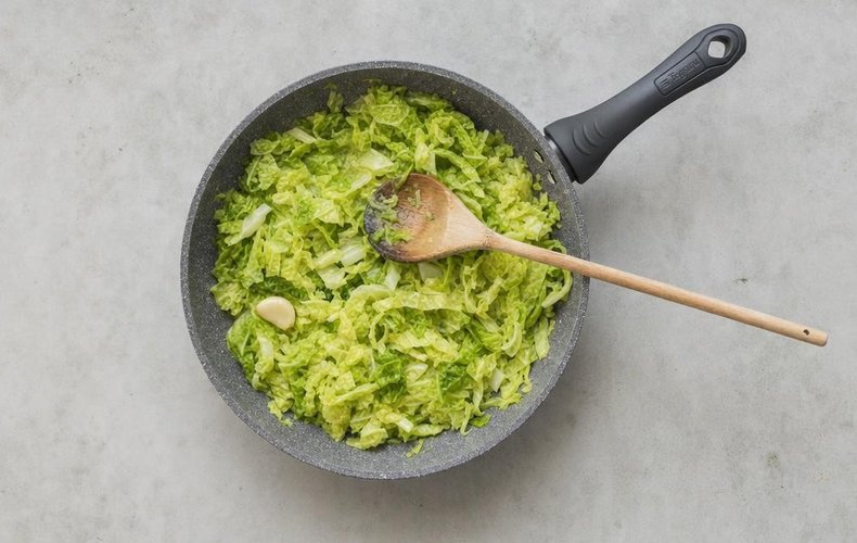 Lasagna with Meat Ragù and Savoy Cabbage, step 4: sliced Savoy cabbage braised in a skillet with garlic