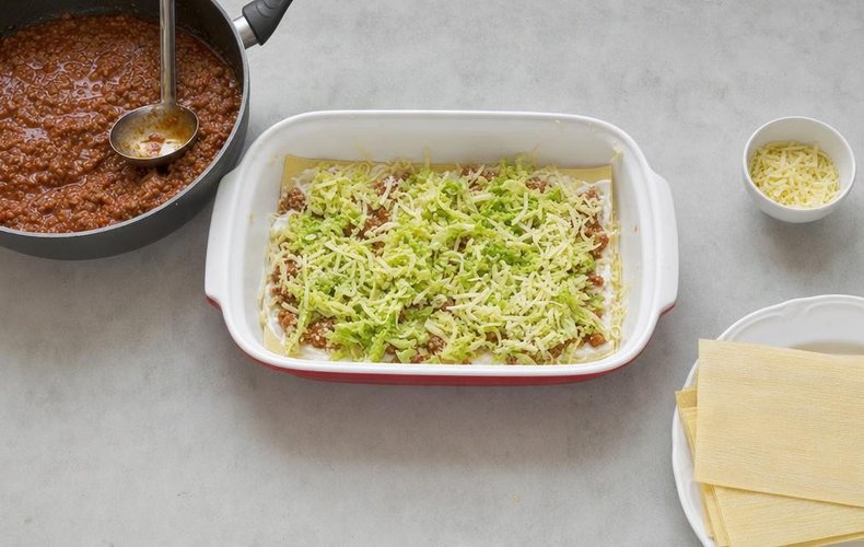 Lasagna with Meat Ragù and Savoy Cabbage, step 5: layers of pasta, béchamel, ragù, cabbage and Emmental in a baking dish