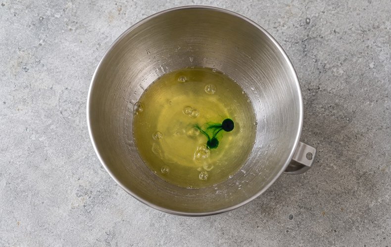 Meringue Christmas Trees, step 1: egg whites, lemon juice and green coloring in a stand mixer bowl