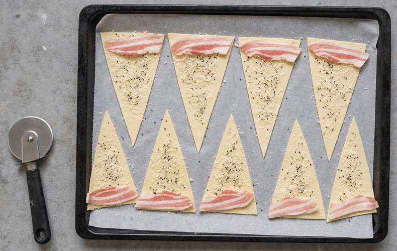 Puff pastry triangles with Parmesan, sesame seeds and a slice of bacon