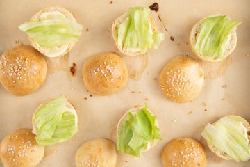 Assembling the mini burgers with mayonnaise and lettuce
