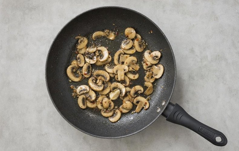 Mushroom and Brie Crostini, step 3: the mushrooms cooking in a skillet with oil and garlic